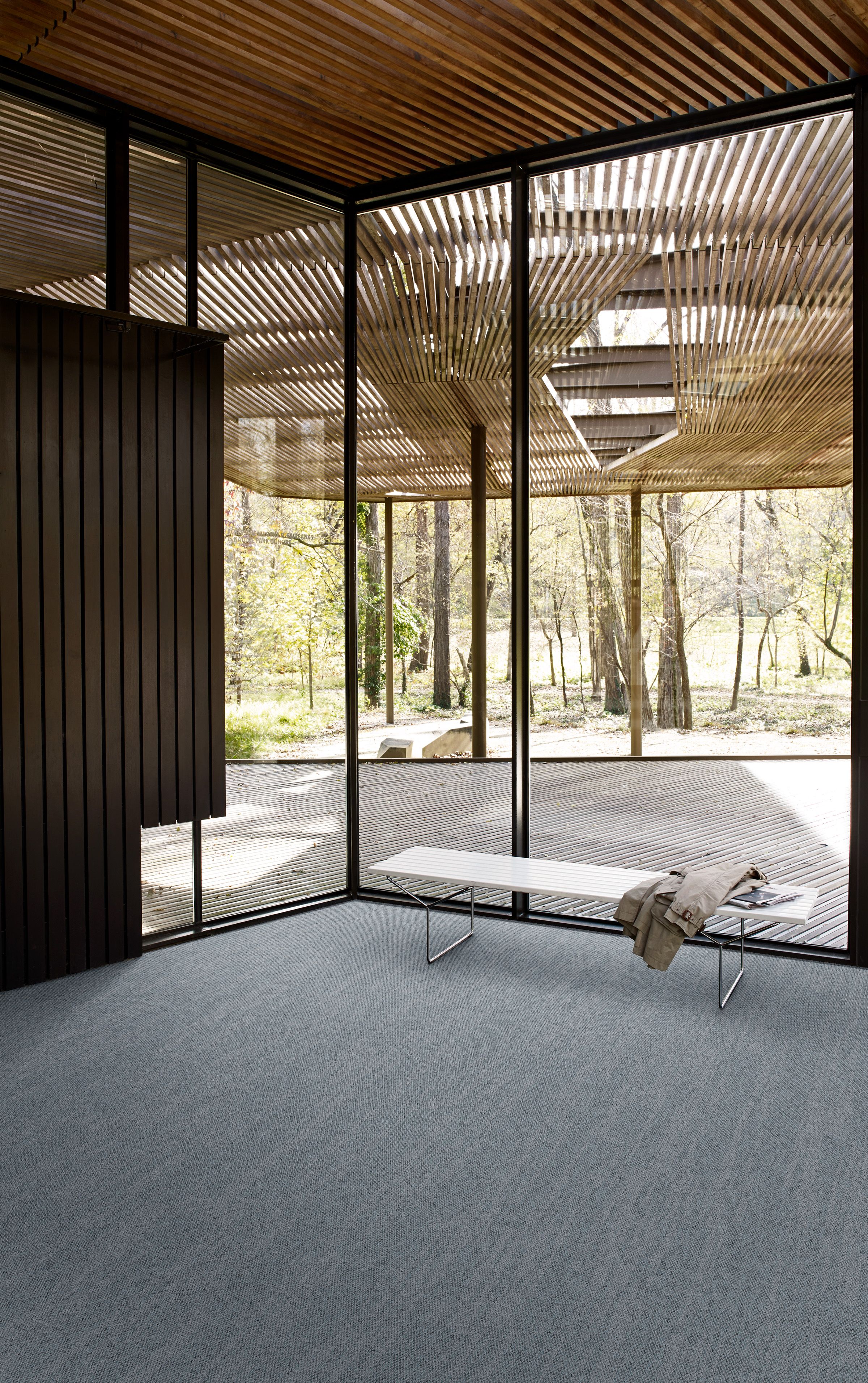 Interface Tide Pool Wave carpet tile in open room with bench and jacket image number 1